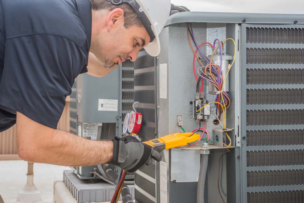 technician repairing an HVAC system Bradenton, FL